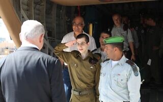 דוד מידן מאחורי גלעד שליט עם השבתו לארץ, 18 באוקטובר 2011 (צילום: דובר צה"ל) דוד מידן מאחורי גלעד שליט עם השבתו לארץ, 18 באוקטובר 2011 (צילום: דובר צה"ל)
