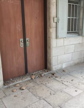רסיסי אגרטל שנופץ על דלת המנזר הפולני בירושלים. יולי 2023 (צילום: ללא)