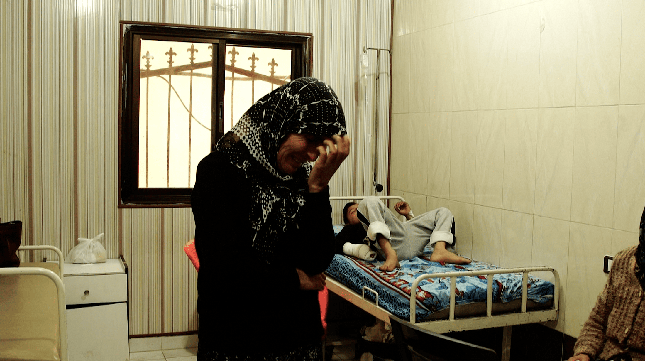 אישה ובנה הפצוע ממתינים בבית חולים מאולתר שנבנה לאחר הפלישה לעפרין (צילום: Jewan Abdi/Ronak Press)