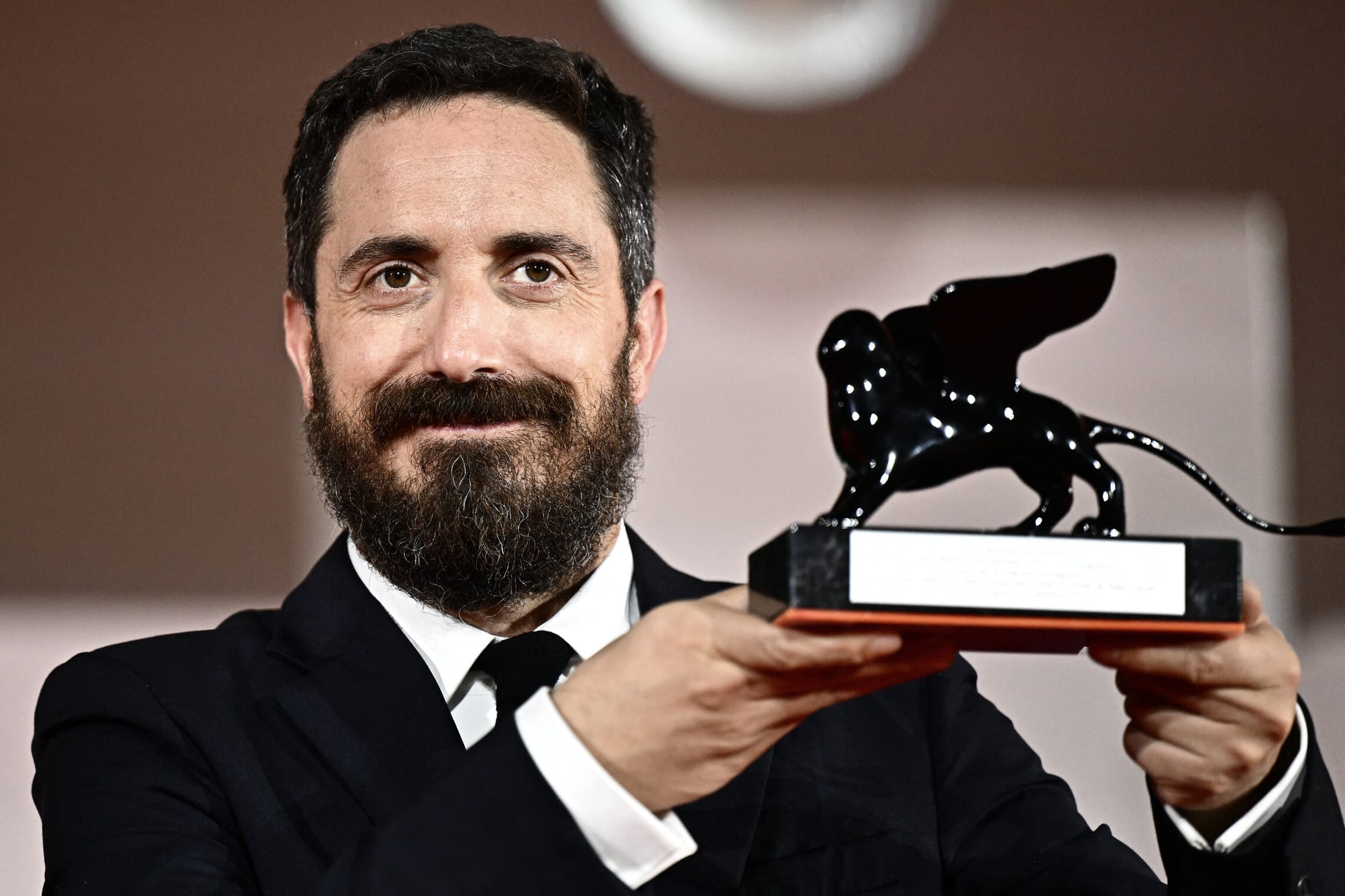 הבמאי הצ&#039;יליאני פבלו לריין מחזיק את הפרס עבור התסריט הטוב ביותר בפסטיבל הסרטים של ונציה, 9 בספטמבר 2023 (צילום: GABRIEL BOUYS / AFP)
