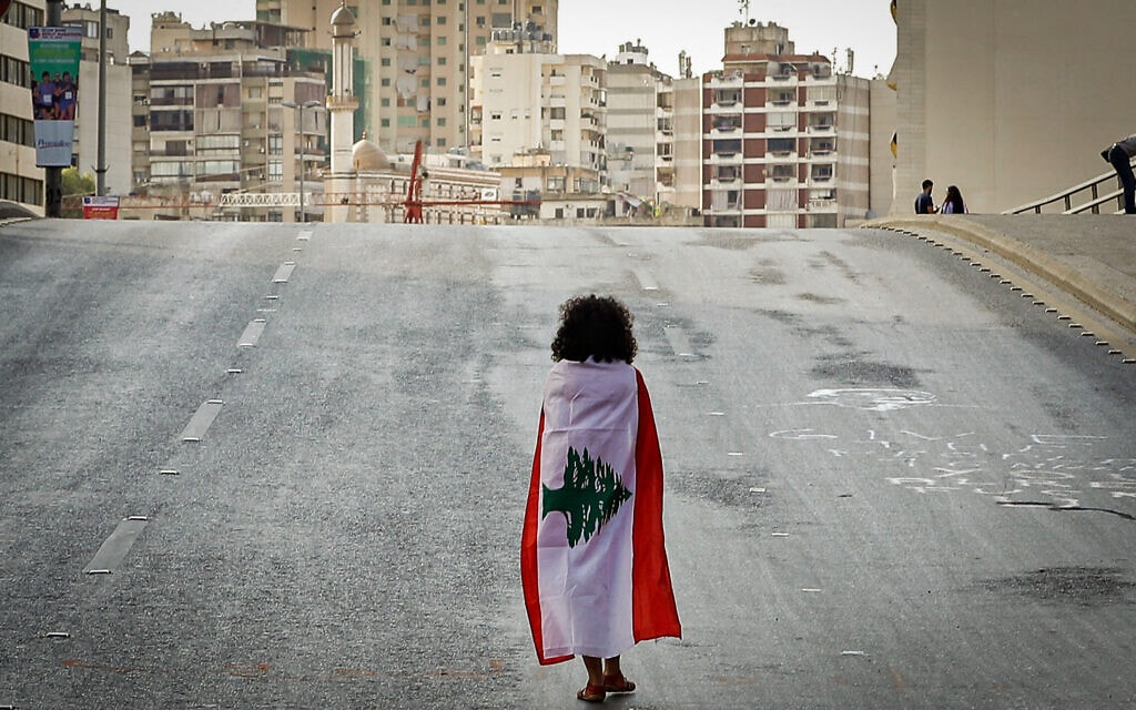 מפגינה עטויה בדגל לבנון במרכז ביירות באוקטובר 2019 (צילום: JOSEPH EID / AFP)