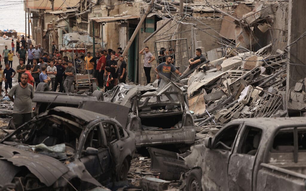 פלסטינים בוחנים את ההרס לאחר תקיפה אווירית של צה"ל במחנה הפליטים שאטי, 9 באוקטובר 2023 (צילום: Mahmud Hams / AFP)