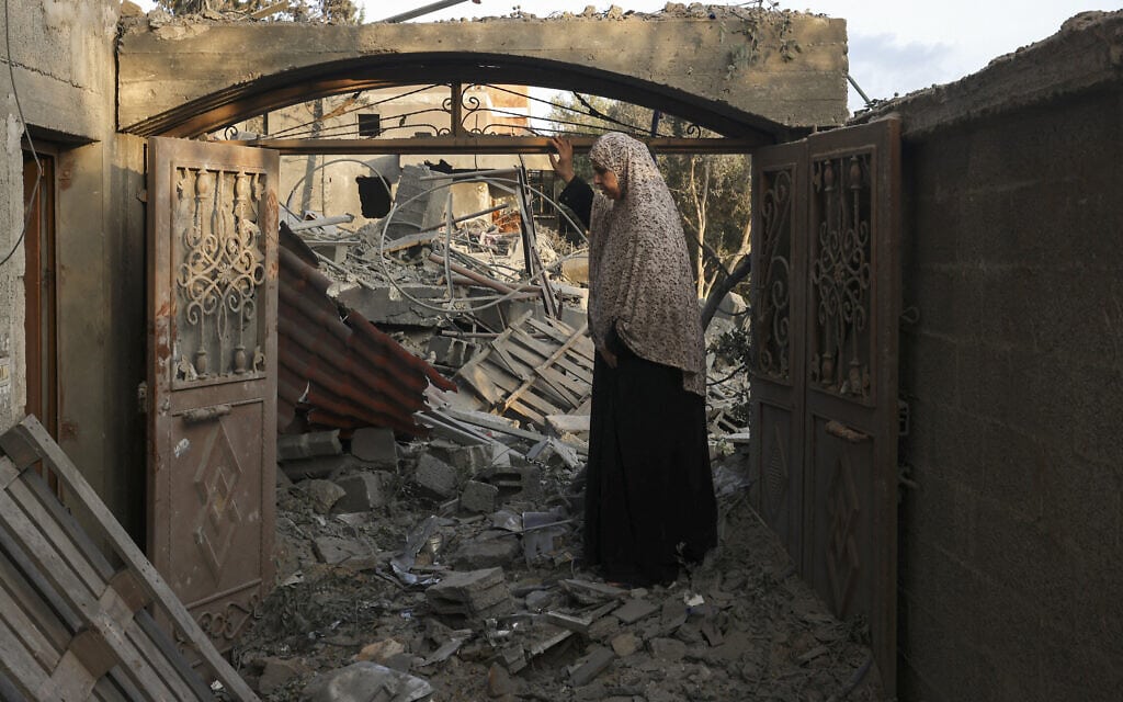 פלסטינית מעזה בוחנת את הנזק שנגרם לביתה בעקבות תקיפה אווירית ישראלית, 14 באוקטובר 2023 (צילום: MOHAMMED ABED / AFP)