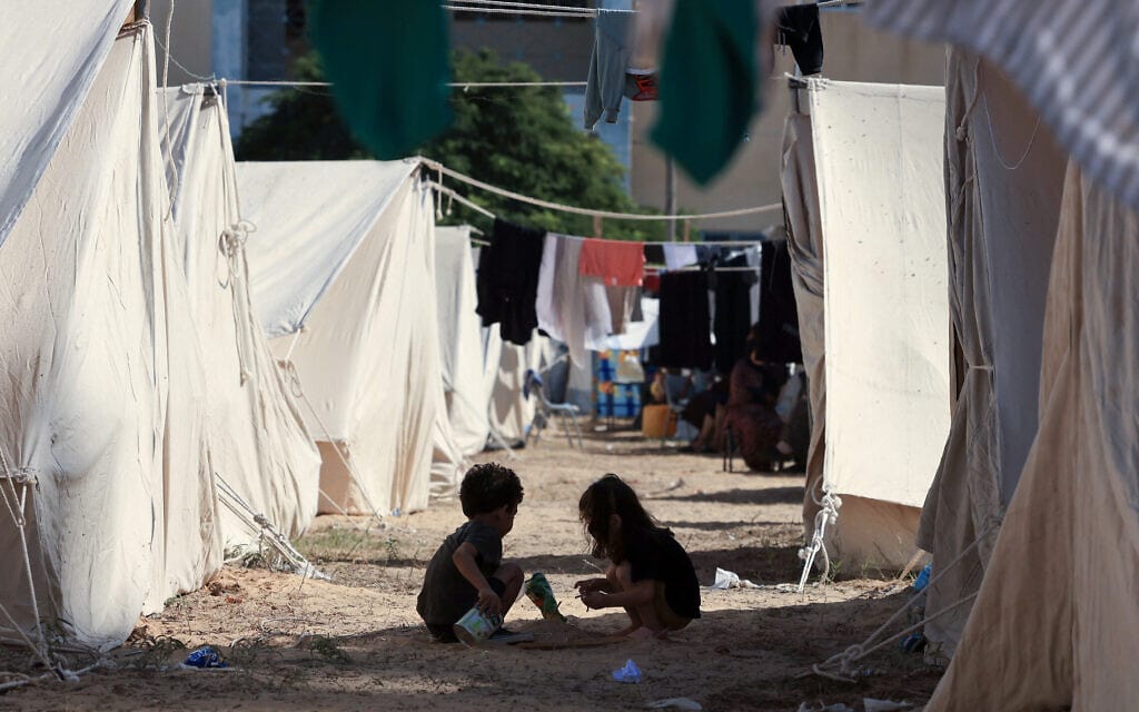 ילדים משחקים בין האוהלים במרכז של סוכנות הפליטים אונר&quot;א בחאן יונס, 19 באוקטובר 2023 (צילום: MAHMUD HAMS / AFP)