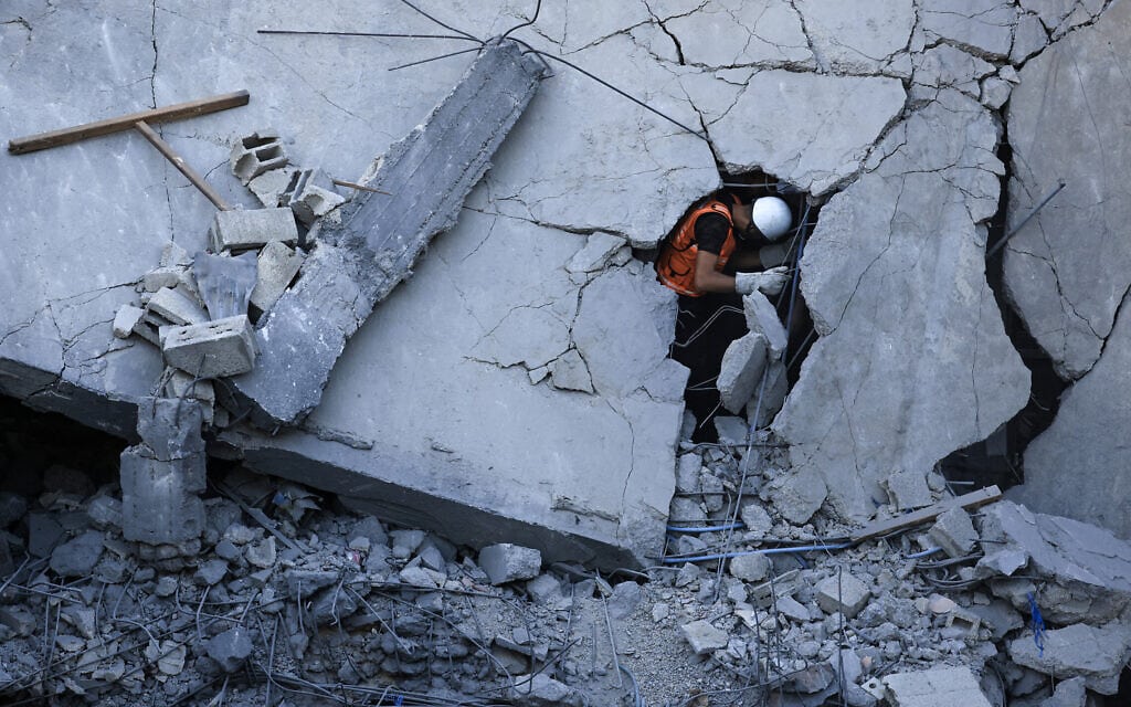 איש חילוץ פלסטיני מחפש ניצולים בבנה שנפגע מירי חיל האוויר בעזה, 19 באוקטובר 2023 (צילום: MAHMUD HAMS / AFP)