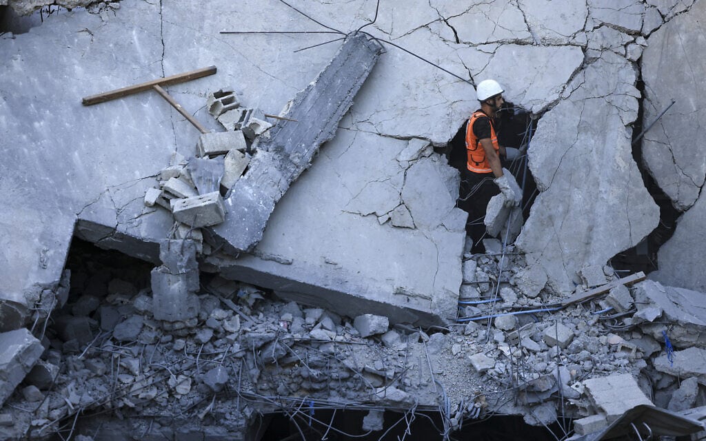 מחלץ מחפש ניצולים במבנה שהופצץ על ידי ישראל בחאן יונס, 19 באוקטובר 2023 (צילום: MAHMUD HAMS / AFP)