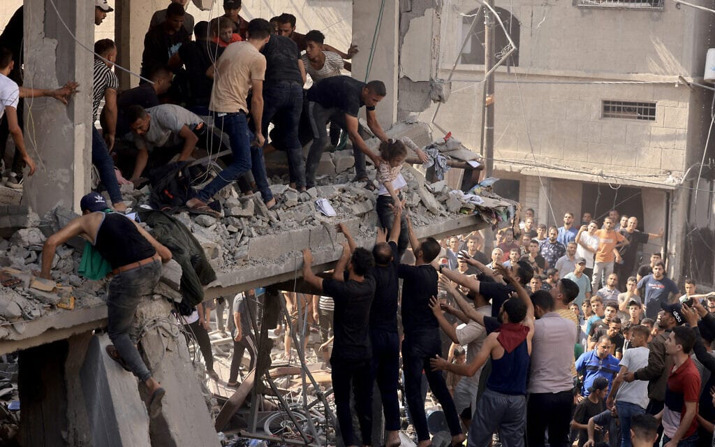 פלסטינים בחאן יונס מפנים נפגעים מהפצצה ישראלית בעיר, 24 באוקטובר 2023 (צילום: MAHMUD HAMS / AFP)