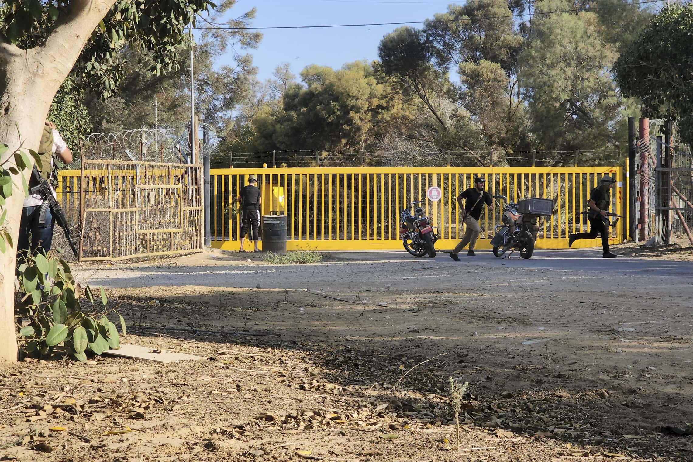 מחבלי חמאס על השער של קיבוץ ניר עוז, 7 באוקטובר 2023 (צילום: AP Photo/Hassan Eslaiah)