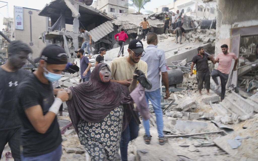 פלסטינית, שנפגעה בהפצצת צה"ל בדיר אל-בלח, מפונה מהמקום, 22 באוקטובר 2023 (צילום: AP Photo / Hatem Moussa)