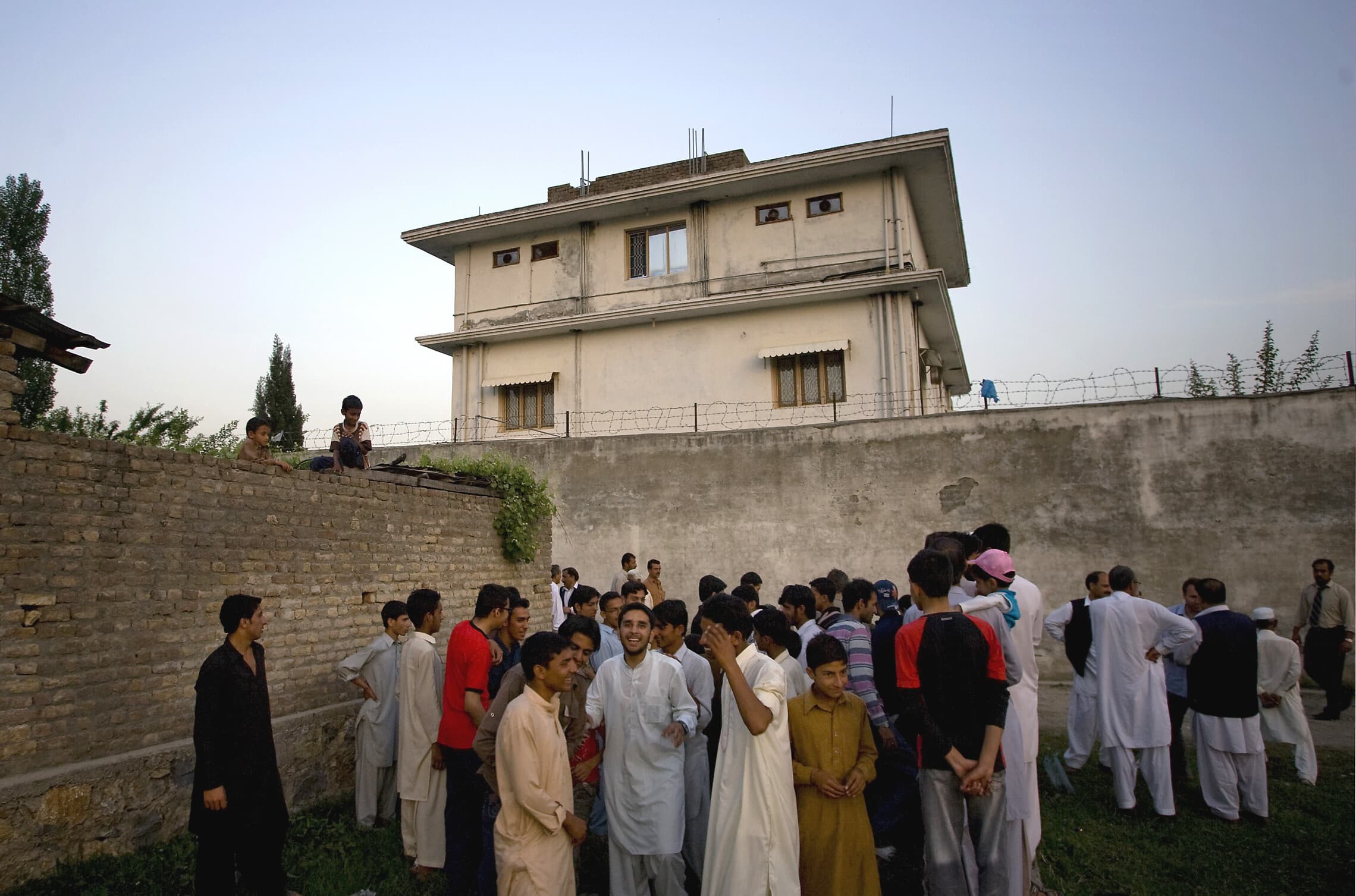 תושבים מקומיים מתכנסים מחוץ לבית שבו חוסל אוסמה בן לאדן באבוטאבאד, פקיסטן, 8 במאי 2013 (צילום: AP Photo/B.K. Bangash)