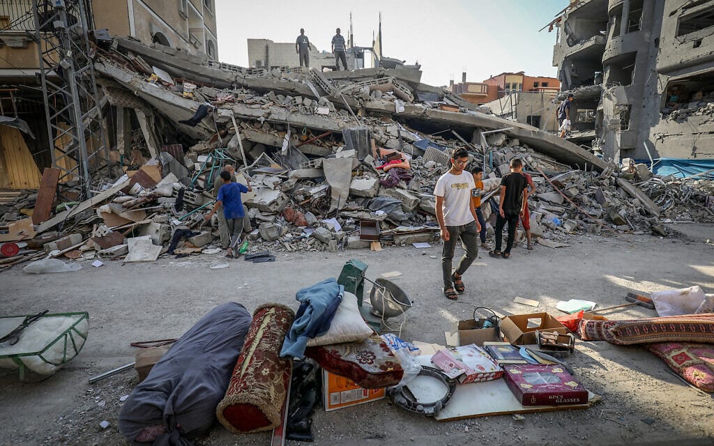 פלסטינים סורקים מבנים שהופצצו על ידי צה"ל בעזה. 12 באוקטובר 2023 (צילום: Abed Rahim Khatib/Flash90)
