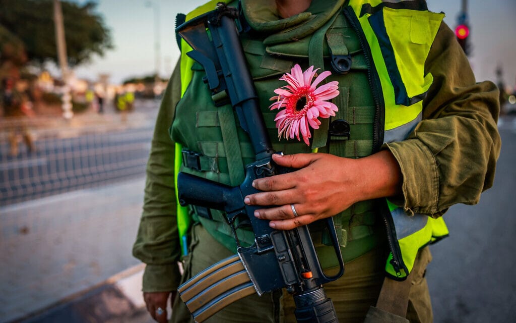 חייל ישראלי מחזיק פרח, 12 באוקטובר 2023 (צילום: Chaim Goldberg/Flash90)