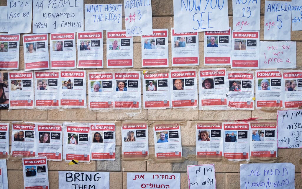 משפחות החטופים והנעדרים ממתקפת חמאס תולים דפי מידע על יקיריהן על חומת הקריה בתל אביב, 14 באוקטובר 2023 (צילום: אבשלום ששוני/פלאש90)