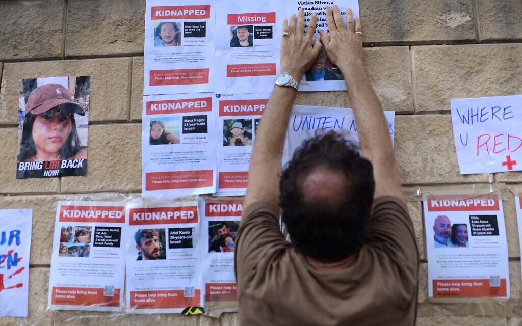 משפחות החטופים והנעדרים ממתקפת חמאס תולים דפי מידע על יקיריהן על חומת הקריה בתל אביב, 14 באוקטובר 2023 (צילום: תומר נויברג/פלאש90)