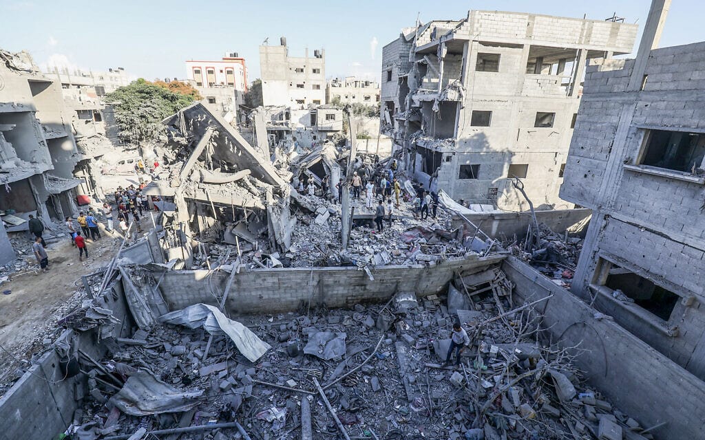 פלסטינים ליד הריסות בניין שנפגע בהפצצות ברפיח. 18 באוקטובר 2023 (צילום: Abed Rahim Khatib/Flash90)