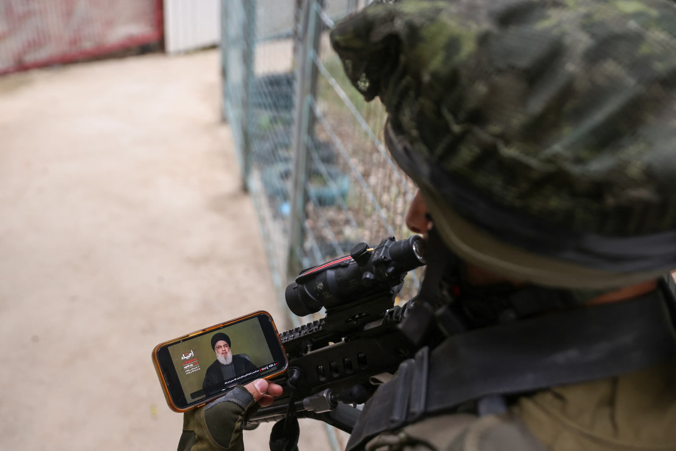 חייל צה&quot;ל בגבול לבנון צופה בנאומו של מנהיג חיזבאללה חסן נסראללה בטלפון, 11 בנובמבר 2023 (צילום: jalaa marey / AFP)