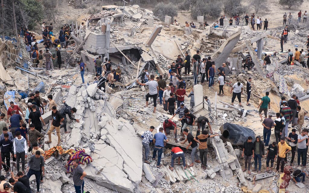 אנשי חילוץ ותושבים מחפשים ניצולים בין ההריסות של מבנה בחאן יונס שהופצץ על ידי ישראל, 12 בנובמבר 2023 (צילום: MAHMUD HAMS / AFP)
