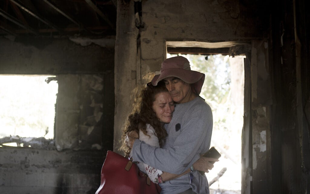 חברי קיבוץ ניר עוז מבקרים בביתה ההרוס של כרמלה דן בת ה-80 שנחטפה לעזה. 30 באוקטובר 2023 (צילום: AP Photo/Maya Alleruzzo)