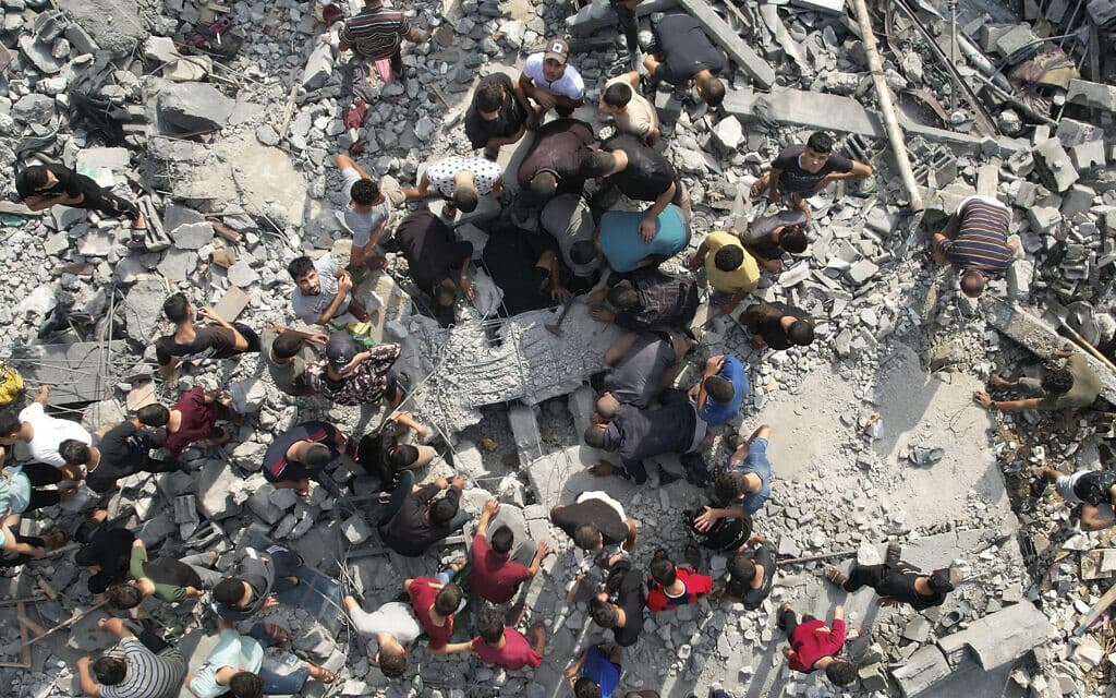 פלסטינים מחפשים ניצולים במבנה במחנה הפליטים מע'אזי שהופצץ על ידי ישראל, 5 בנובמבר 2023 (צילום: AP Photo / Hatem Moussa)
