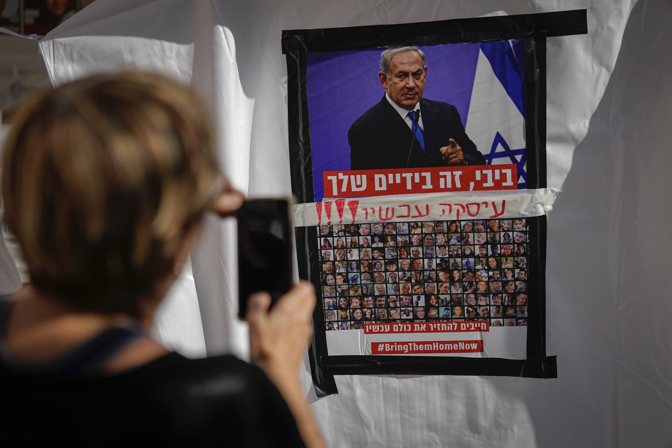 שלט בתל אביב הקורא לראש הממשלה בנימין נתניהו לחתום על עסקה לשחרור החטופים, 21 בנובמבר 2023 (צילום: AP Photo/Ariel Schalit)
