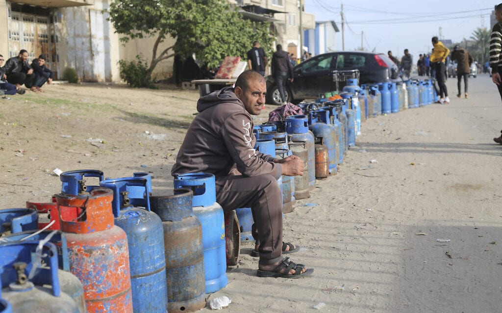 פלסטינים ממתינים לחלוקת גז בישול ביום השני של ההפוגה בלחמה בעה, 25 בנובמבר 2023 (צילום: AP Photo/Hatem Ali)