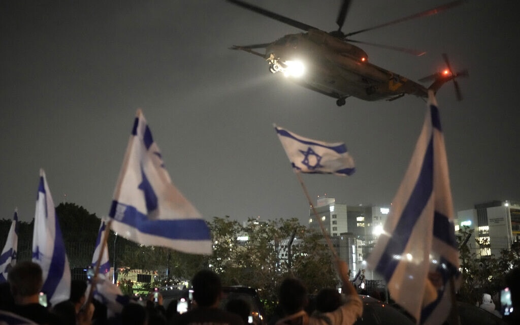 ישראלים מנופפים בדגלים בזמן שמסוק עם משוחררים משבי חמאס נוחת בבית החולים שניידר, 26 בנובמבר 2023 (צילום: AP Photo/Leo Correa)