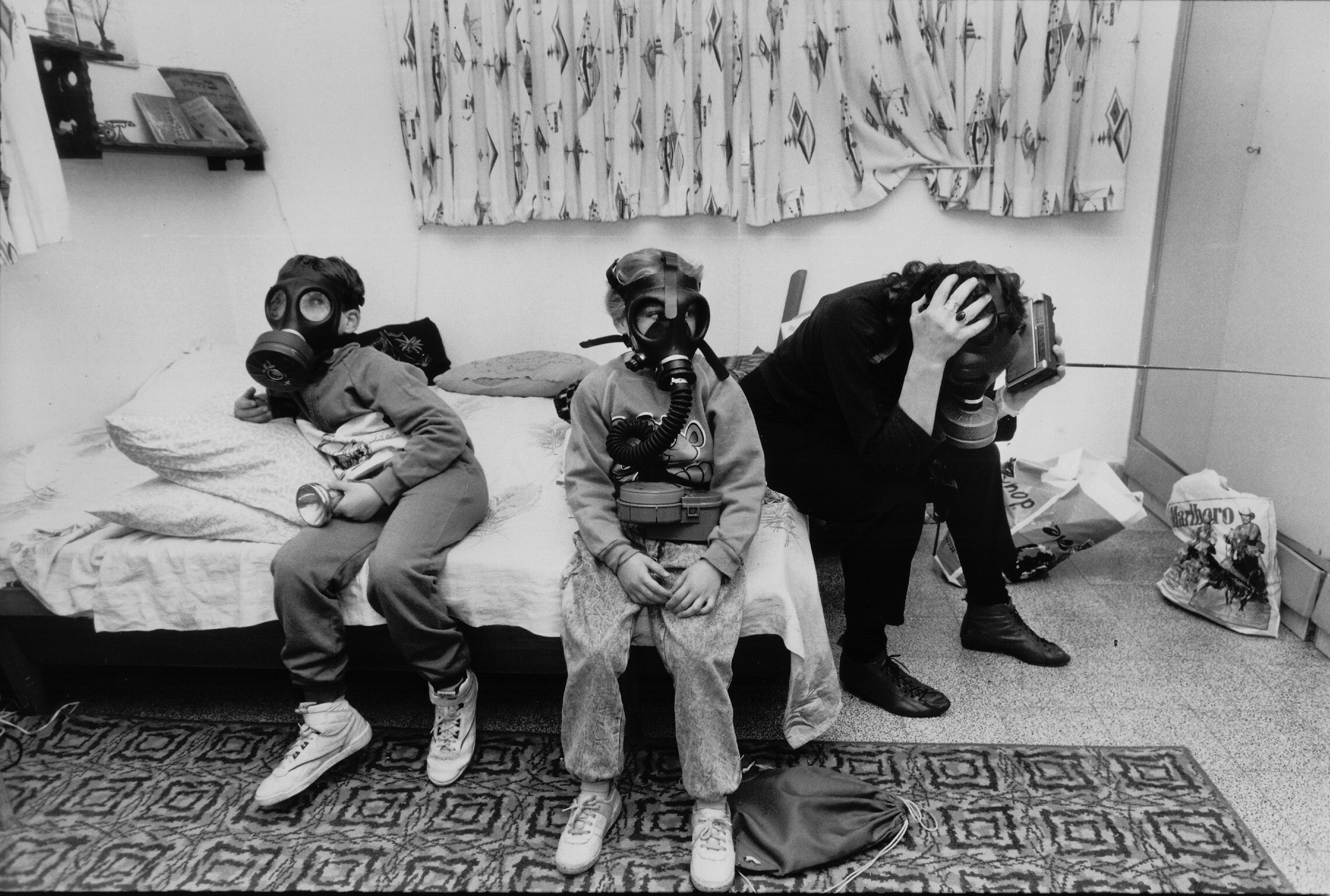 אילוסטרציה: משפחה לובשת מסכות אב&quot;כ בתל אביב בזמן מלחמת המפרץ, 1991 (צילום: משה שי/פלאש90)