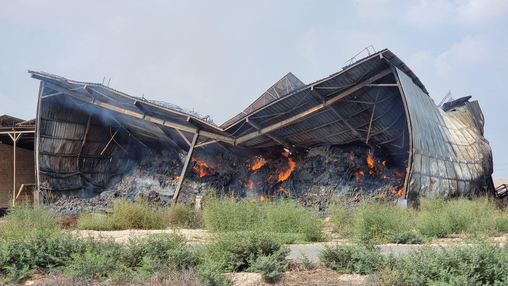 סככה עולה באש בעקבות מתקפת מחבלי חמאס בקיבוץ עלומים, 7 באוקטובר 2023 (צילום: סטיבי מרקוס)
