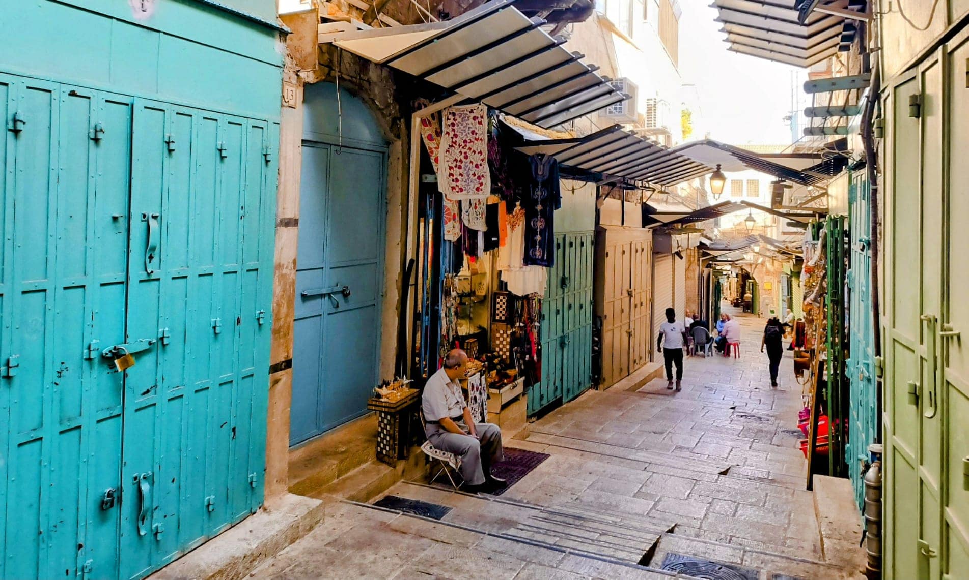 בעל חנות מזכרות יושב ברחוב כמעט ריק בעיר העתיקה בירושלים, 6 בנובמבר 2023 (צילום: ג'אנלוקה פקיאני)