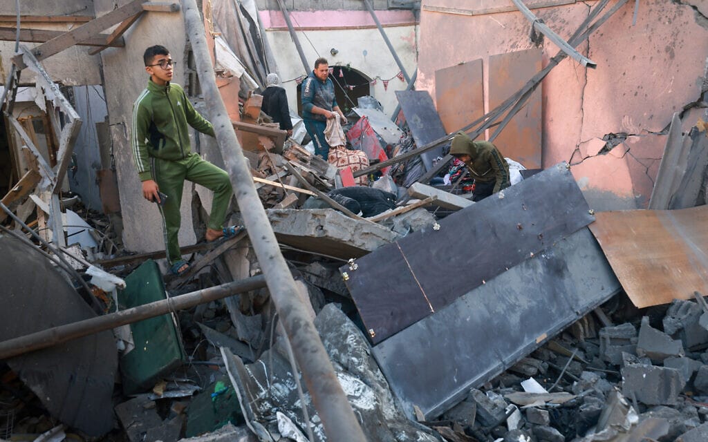 פלסטינים במבנה ברפיח שהופצץ על ידי ישראל, 2 בדצמבר 2023 (צילום: MOHAMMED ABED / AFP)