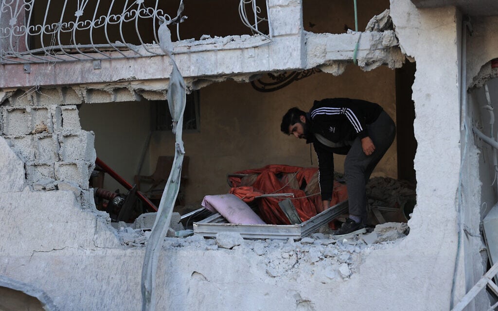 פלסטיני בוחן את הנזק שנגרם למבנה בתקיפה ישראלית ברפיח, 9 בדצמבר 2023 (צילום: SAID KHATIB / AFP)