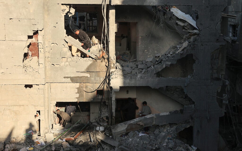 פלסטינים בוחנים את הנזק שנגרם למבנה בהפצצה ישראלית ברפיח, 9 בדצמבר 2023 (צילום: SAID KHATIB / AFP)