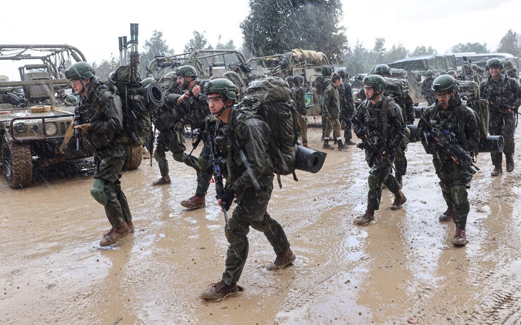 חיילי צה&quot;ל צועדים בגשם ובבוץ בדרום רצועת עזה, 13 בדצמבר 2023 (צילום: JACK GUEZ / AFP)