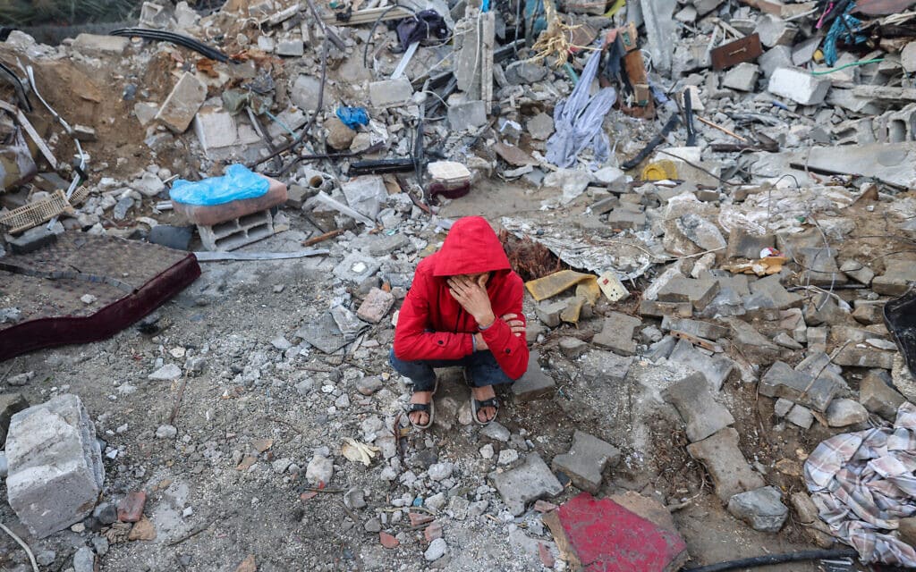 צעיר פלסטיני בחורבות אתר ברפיח שהופצץ על ידי ישראל, 15 בדצמבר 2023 (צילום: MOHAMMED ABED / AFP)