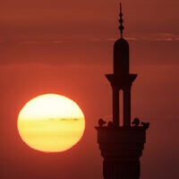 השמש שוקעת ברקע מסגד ברפיח ברצועת עזה, 25 בדצמבר 2023
