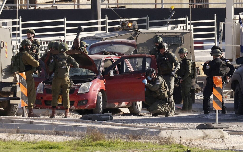 חיילי צה"ל סביב מכונית, שלפי החשד, שימשה לביצוע פיגוע דריסה דרומית לחברון, 30 בדצמבר 2023 (צילום: HAZEM BADER / AFP)
