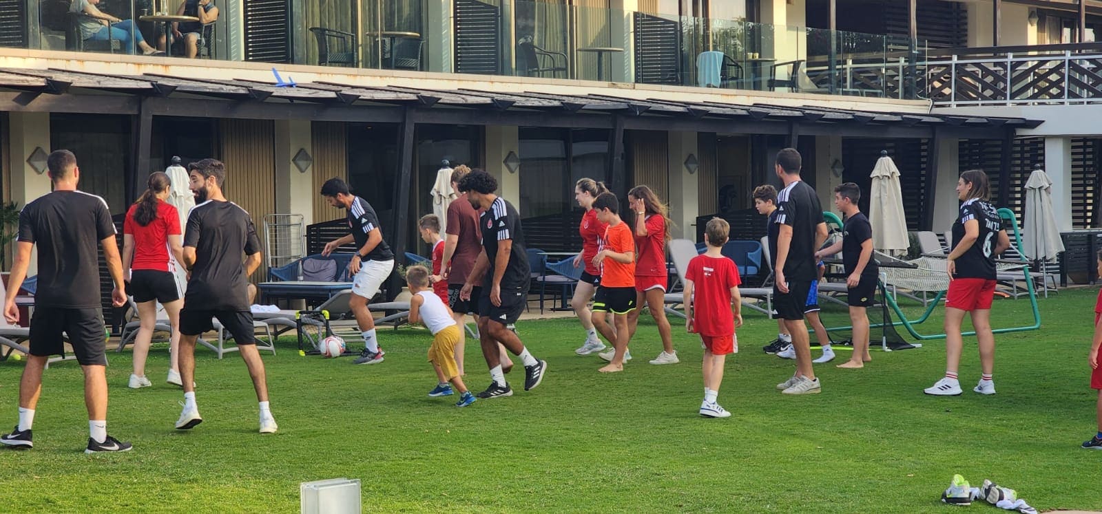 חברי קיבוץ מפלסים משחקים על הדשא של מלון דן אכדיה בהרצליה, נובמבר 2023 (צילום: קיבוץ מפלסים)
