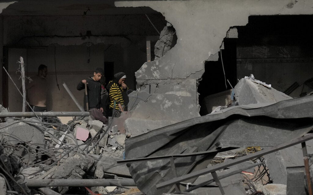 פלסטינים בוחנים את הנזק שנגרם לביתם בהפצצה של צה"ל בא-זוואידה שבמרכז רצועת עזה, 10 בדצמבר 2023 (צילום: AP Photo/Hatem Moussa)