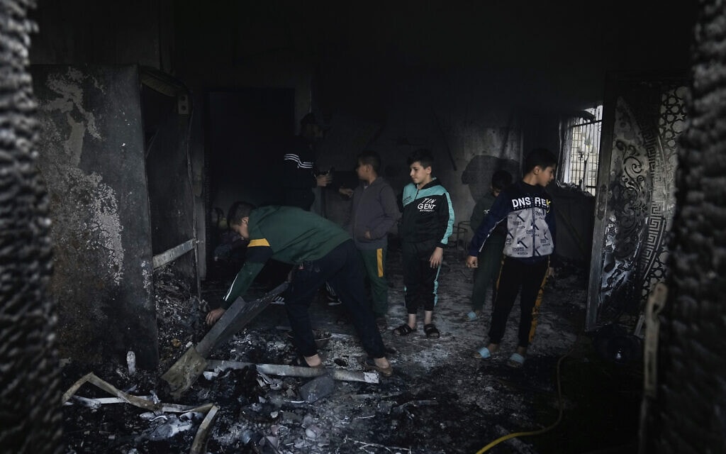 פלסטינים בבית שנפגע בפעילות של כוחות הביטחון, 13 בדצמבר 2023 (צילום: AP Photo/Majdi Mohammed)
