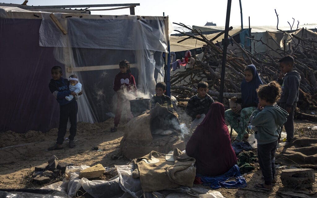 עזתים מבשלים בעיר אוהלים זמנית ברצועת עזה, 18 בדצמבר 2023 (צילום: AP Photo/Fatima Shbair)