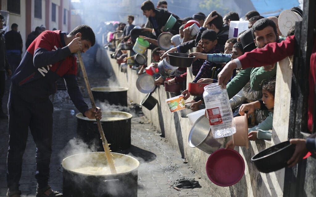פלסטינים עומדים בתור לקבל מזון ברפיח שבדרום רצועת עזה, 20 בדצמבר 2023 (צילום: AP Photo/Hatem Ali)