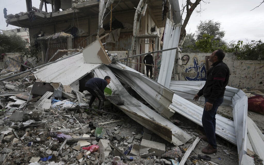 פלסטינים באזור שהופצץ על ידי ישראל במחנה הפליטים נוסייראת שברצועת עזה, 23 בדצמבר 2023 (צילום: AP Photo/Adel Hana)