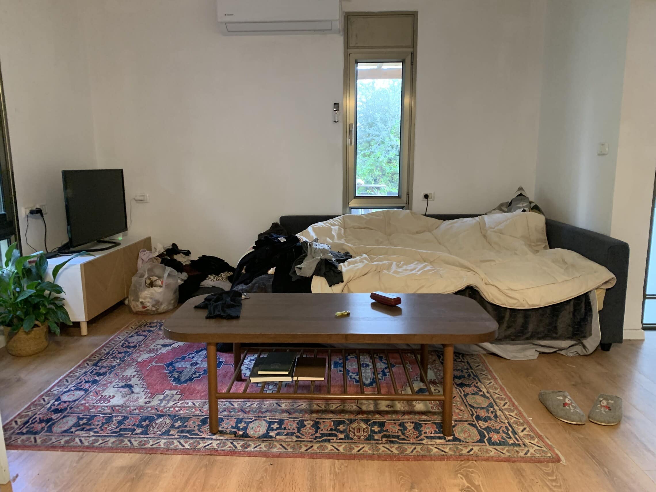 הספה בסלון שעליה ישנה חדוה שתם-עבאדי בדירה הזמנית בעמיקם, דצמבר 2023 (צילום: תמר מור סלע)