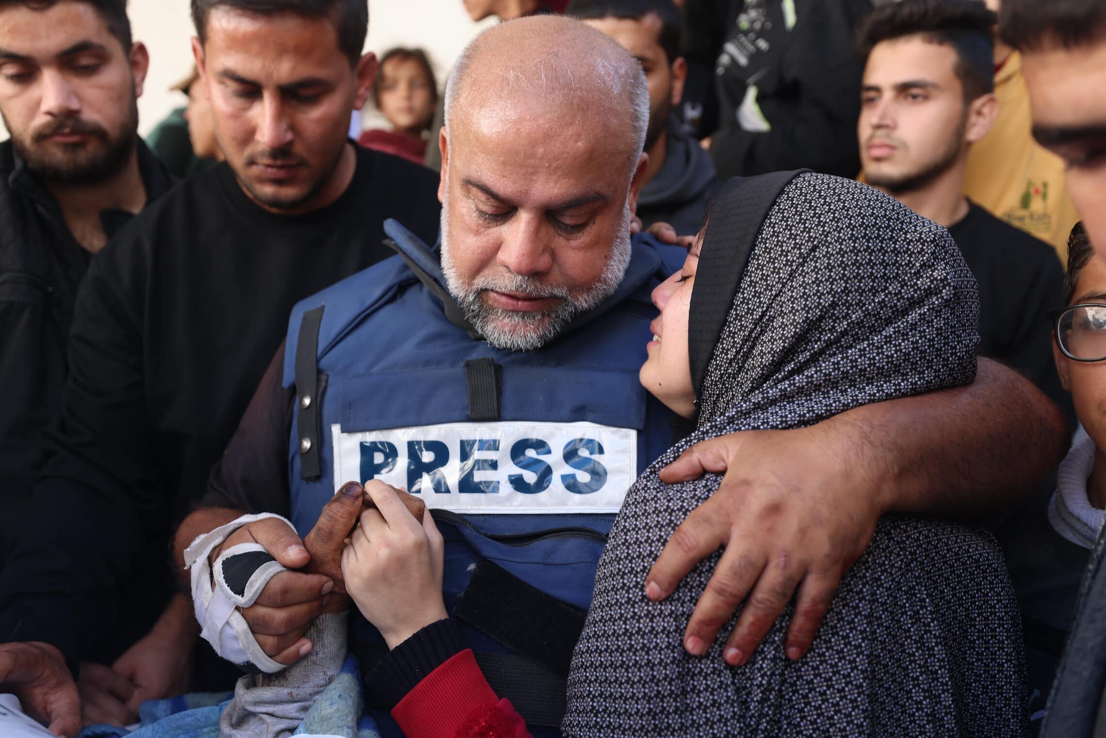 עיתונאי אל־ג&#039;זירה ואיל דחדוח מחבק את בתו בהלוויית בנו בעזה, 7 בינואר 2024 (צילום: AFP)