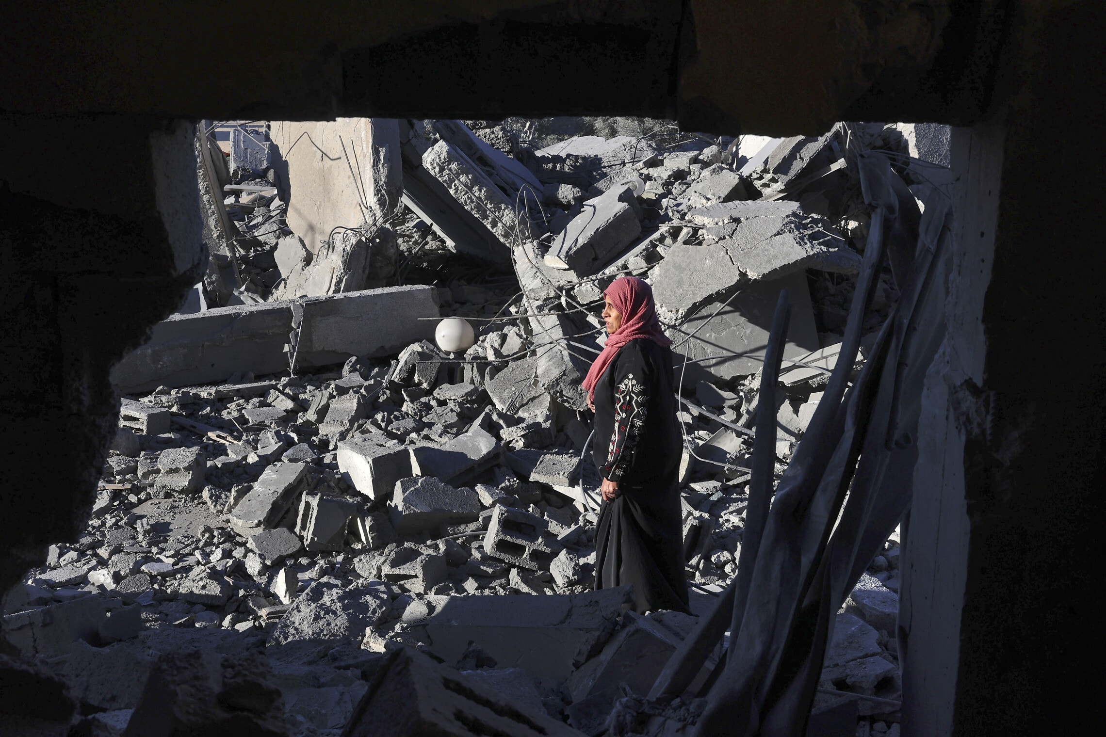 אישה פלסטינית צועדת בין ההריסות ברפיח, 13 בינואר 2024 (צילום: AFP)