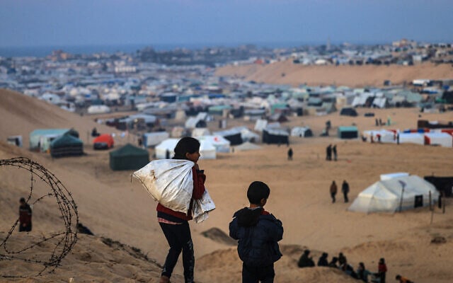 ילדים פלסטינים עקורים מול מחנה האוהלים המאולתר ברפיח, 19 בינואר 2024