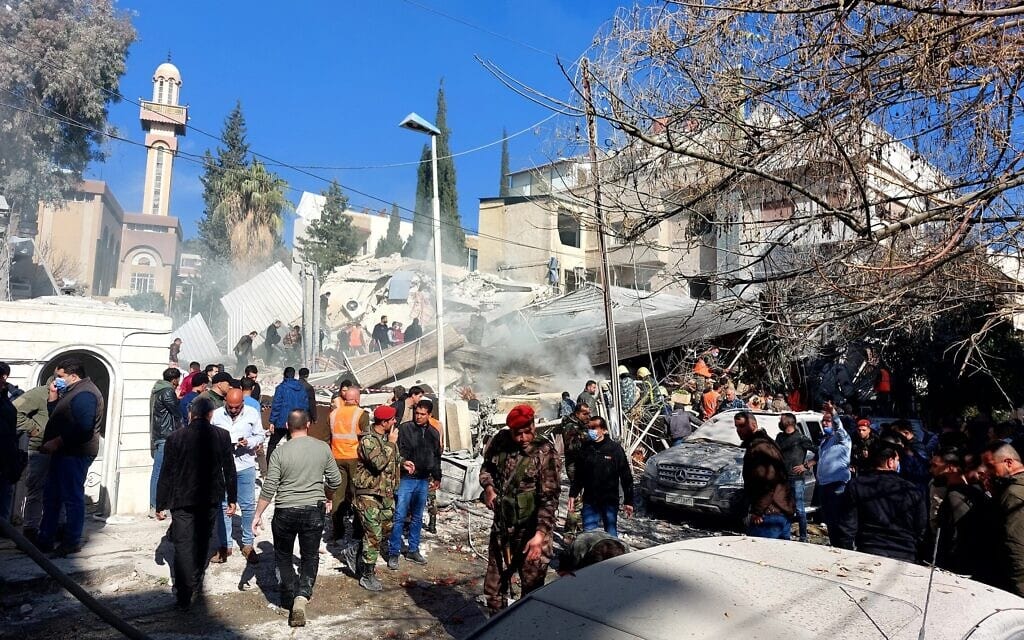 אזרחים וכוחות ביטחון והצלה ליד הבניין שהושמד בתקיפה בדמשק. 20 בינואר 2024 (צילום: Louai Beshara / AFP)