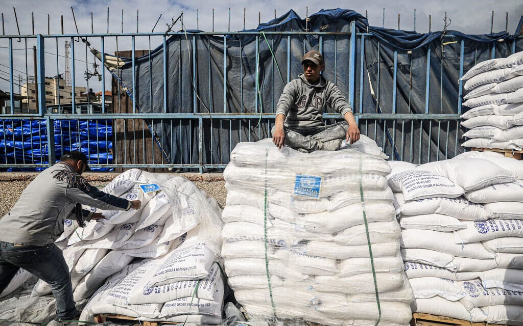 עובדי אונר"א מטפלים בשקי סיוע הומניטרי שהוכנס לרצועת עזה במעבר רפיח, 28 בינואר 2024 (צילום: AFP)