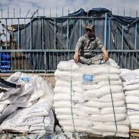 עובדי אונר"א מטפלים בשקי סיוע הומניטרי שהוכנס לרצועת עזה במעבר רפיח, 28 בינואר 2024