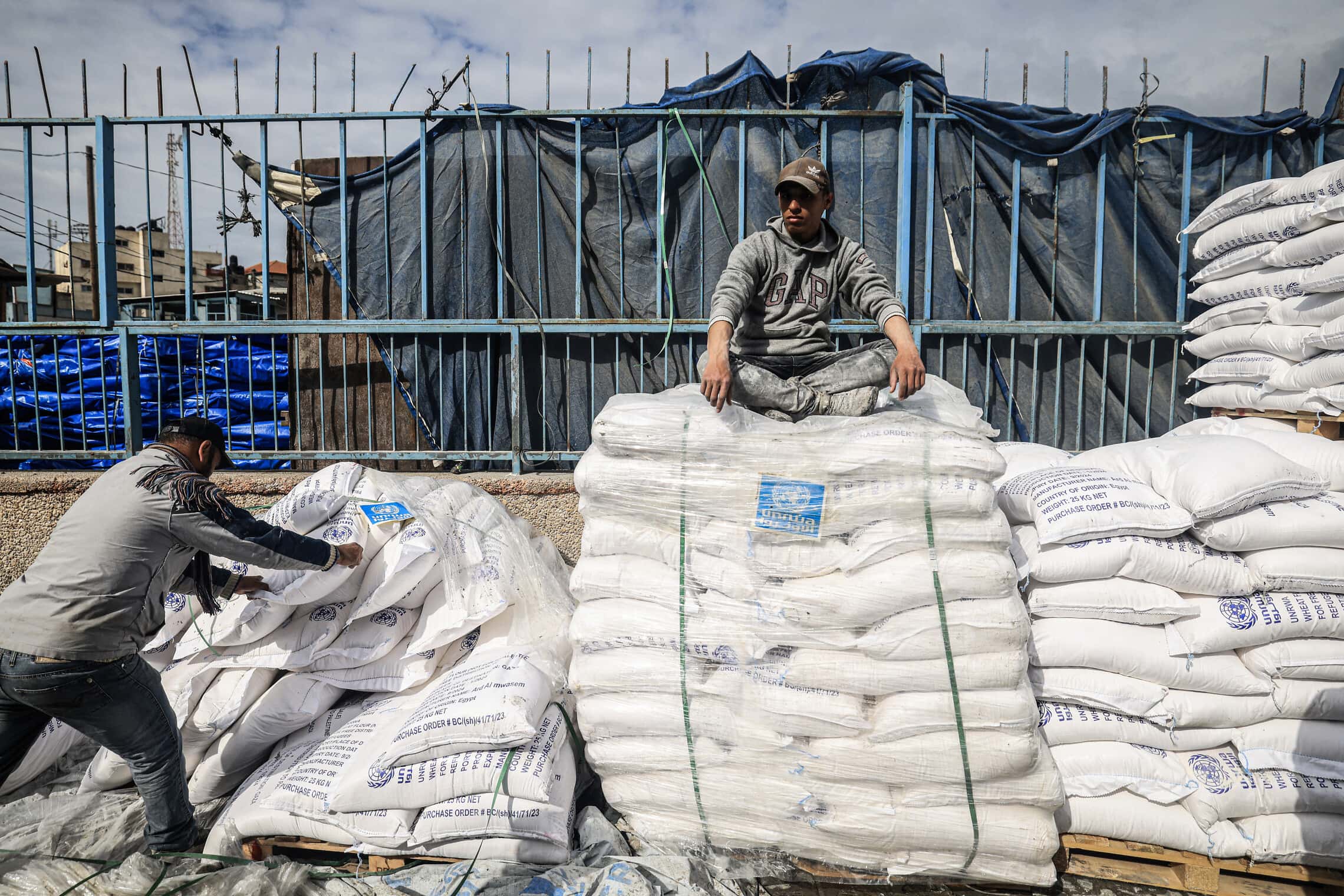 עובדי אונר&quot;א מטפלים בשקי סיוע הומניטרי שהוכנס לרצועת עזה במעבר רפיח, 28 בינואר 2024 (צילום: AFP)